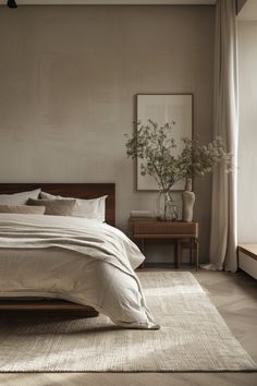 a bedroom with a bed, nightstands and plants on the side table in front of it