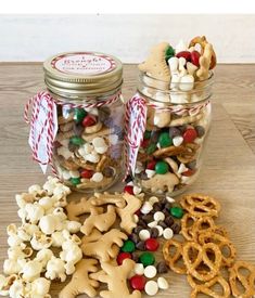 two glass jars filled with cookies and pretzels on top of a wooden table