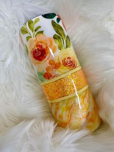 an orange and yellow vase sitting on top of white fur