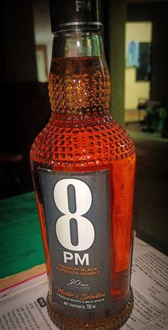 a bottle of rum sitting on top of a table next to a paper with the number 8