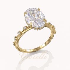 an oval cut diamond ring set in yellow gold with diamonds around the band and shoulders