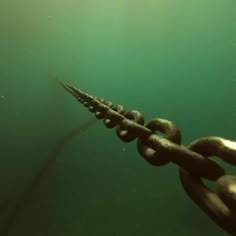 a chain link is attached to the bottom of an ocean surface with green water in the background