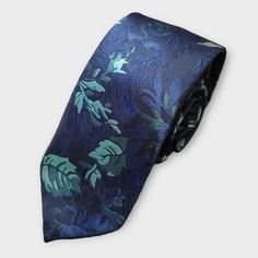 Elevate your formal wear look with our Navy Blue Teal Floral Silk Tie Pocket Square Cufflink Set. The high-quality silk fabric is perfect for weddings and other special occasions, and the navy blue and teal floral pattern is sure to turn heads. The set includes a tie, pocket square, and cufflinks, making it a convenient and stylish choice for any formal event. 100% Silk Handmade Package Includes: Tie, Pocket Square & Cufflinks. Length: 59" Width: 3.34" Warm iron if needed Blue Elegant Suit And Tie Accessories For Formal Occasions, Elegant Navy Suit And Tie Accessories For Wedding, Elegant Blue Suit And Tie Accessories For Wedding, Formal Blue Adjustable Suit And Tie Accessories, Blue Adjustable Suit And Tie Accessories For Formal Occasions, Adjustable Blue Ties For Formal Occasions, Luxury Elegant Blue Ties, Luxury Navy Ties For Semi-formal Occasions, Elegant Blue Silk Pocket Square