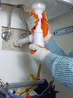 a plumber working on a sink with tools under it