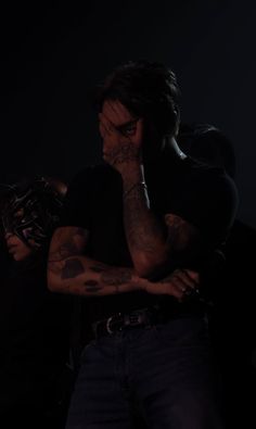 a man with tattoos standing in the dark