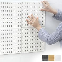 a woman placing her hands on a pegboard with different color swatches and colors