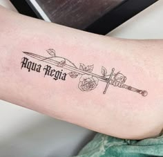 an arrow tattoo on the arm with roses and words written in black ink above it