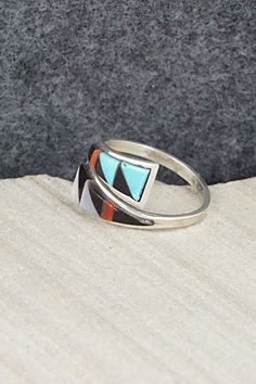 This turquoise, coral, mother of pearl, onyx and sterling silver inlay ring was made by Zuni silversmith Mya Qualo. The inside is signed and stamped sterling.Size: 7Length: 1/2"Free shipping on all orders! We ship with USPS and always include tracking. All orders ship within a day of payment.Returns are accepted up to 30 days after you receive your order. Just send us a message. Our shop offers cash back or store credit. The item must be returned in new condition. Red Sterling Silver Ring With Inlay, Red Sterling Silver Rings With Inlay, Southwestern Style Rings With Inlay As Gift, Southwestern Style Rings With Inlay For Gift, Multicolor Inlay Rings For Anniversary, Anniversary Multicolor Inlay Rings, Southwestern Multicolor Inlay Rings, Southwestern Style Multicolor Inlay Rings, Sterling Silver White Inlay Ring