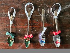 four christmas ornament hanging from hooks on a wooden floor with snowmen and santa hats