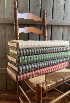 a stack of blankets sitting on top of a wooden chair