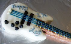 a cake shaped like an electric guitar with blue and white frosting on it's body