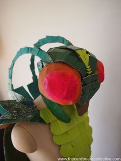 a close up of a paper mache with an apple on it's head