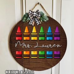 a wooden sign that says mrs lauren with colorful crayons on the front door