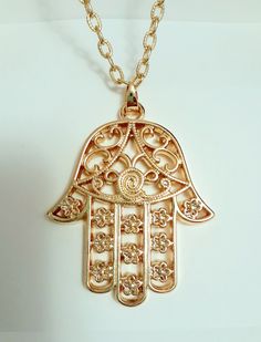 29 inch gold chain with a large Hamsa Hand symbol.  It is a protective sign bringing the owner happiness, luck health and good fortune.  It is also known as the Hand of Miriam and the Hand of Fatima.  The design on the pendant is quite intricate  and the thickness measures  5 millimeters.  Suitable for men or women. Gold Amulet Jewelry For Good Luck, Gold Medallion Necklace For Good Luck, Gold Medallion Charm Necklace For Good Luck, Symbolic Gold Jewelry For Blessing, Spiritual Gold Plated Necklace For Good Luck, Gold Metal Amulet Charm Necklaces, Gold Metal Amulet-style Charm Necklaces, Gold Amulet Style Charm Necklace, Gold Amulet Charm Necklace With Large Pendant