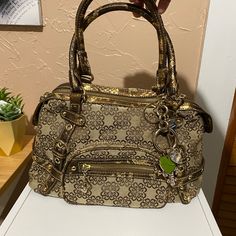 Beautiful Beige, Brown And Gold Faux Snakeskin Hand Bag. Charms Attached To Bag. All Charm Rhinestones Are Intact 11” W , 7” H 3 Zipper Pockets 3 Insert Pockets Unused- Tag Fell Off Gold Tote Satchel With Zipper Closure, Gold Crossbody Bag With Silver-tone Hardware, Gold Satchel With Silver-tone Hardware And Top Handle, Gold Satchel With Silver-tone Hardware, Travel Satchel In Gold With Silver-tone Hardware, Travel Satchel With Silver-tone Hardware In Gold, Gold Satchel Bag With Silver-tone Hardware, Gold Satchel With Silver-tone Hardware For Travel, Gold Rectangular Satchel With Silver-tone Hardware