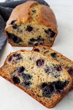 two slices of blueberry bread sitting on top of a white counter next to a gray napkin