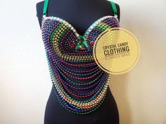 a black mannequin with multicolored beads on it and a green ribbon around the neck