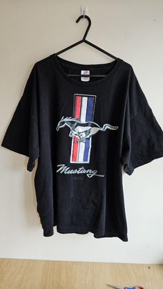 a black mustang shirt hanging on a wall