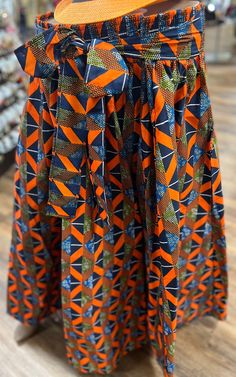 This  is a beautiful ethnic skirt that has an elastic waist band that allows it to fit multiple sizes. A waist tie belt and pockets on the sides for comfort and play. The Length 28 inches long.  Colors Orange , & Blue. Why not add this to your collection of wearable art today, Please don't delay. Traditional Wrap Skirt For Spring, Traditional Pleated Skirt For Summer, Traditional Pleated Summer Skirt, Long Patterned Lined Skirt, Multicolor Long Lined Wrap Skirt, Patterned Long Skirt With Lining, Multicolor Lined Wrap Skirt, Traditional Flared Lined Skirt, Traditional Multicolor Maxi Skirt For Spring