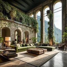 a large living room filled with lots of furniture and greenery on the wall behind it