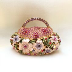 Jewelry Box - Vintage Floral Handbag Vintage Floral Handbag jewelry box is the perfect compartment for storing expensive necklaces, rings, and earrings out of sight! It has an easy to use magnetic attachment to close the floral handbag. The beautiful design is made sturdy and has a good weight. The floral handbag has a rustic and playful design, great for gifting flower lovers/ admirers/fanatic or for personal uses such as storing engagement rings, etc. This gift box is a great collectors item. Elegant Round Case Bag As Gift, Compact Pink Bags For Gifts, Pink Compact Bag For Gifts, Compact Pink Bag For Gifts, Luxury Box-shaped Gift Bags, Gift Multicolor Rectangular Case Bag, Multicolor Rectangular Case Bag For Gift, Elegant Portable Rectangular Jewelry Storage, Multicolor Rectangular Gift Bag