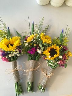 three bouquets of sunflowers tied together with twine