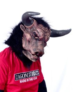 a man in a red shirt with horns on his head wearing a fake demon mask