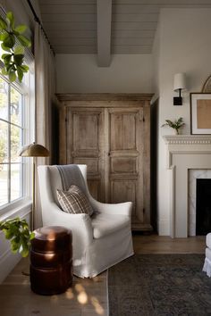 a living room filled with furniture and a fire place in front of a large window