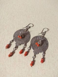 This is an old silver berber earrings from Morocco with Coral beads. It is made of old Silver berber pendant with coral beads. Dangling at the bottom : coral bead. They are a exceptional and unique piece of jewelry. Length : 11 cm (4,3 inches) Width : 4,5 cm (1,7 inches) Weight (Pair) : 29,4 g Traditional Earrings With Natural Stones, Traditional Earrings With Round Natural Stones, Traditional Beaded Pendant Earrings, Traditional Silver Beaded Earrings, Traditional Silver Nickel-free Beaded Earrings, Traditional Sterling Silver Beaded Earrings, Nickel Free, Nickel-free Sterling Silver Traditional Beaded Earrings, Nickel-free Traditional Sterling Silver Beaded Earrings, Traditional Silver Beaded Earrings With Round Beads