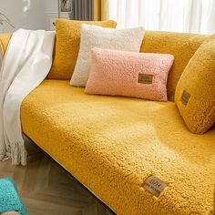 a yellow couch with several pillows on it