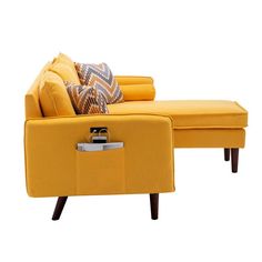 a yellow couch and ottoman with pillows on it