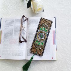 an open book sitting on top of a table next to glasses and a white rose