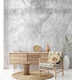 a living room with a chair, table and potted plant on the floor in front of a concrete wall