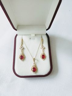 **All orders come with tracked shipping** ** Ready to ship in 1 business day** ** Shipping time to Canada and U.S: 2-5 business days** High quality champagne gold plated Gatsby style earrings and necklace set with red cubic zirconia stones surrounded by beautiful intricate filigree work and small round clear stones at the corners.  The chain is 1mm thick and 46cm long. It is easily adjustable to make it shorter to your desired length simply by pulling on the chain through the round gold bead. It Elegant Ruby Jewelry Sets With Matching Earrings, Ruby Necklaces With Matching Earrings For Gift, Ruby Necklaces With Matching Earrings As Gift, Ruby Necklace With Matching Earrings As A Gift, Red Art Deco Jewelry For Formal Occasions, Fine Jewelry Filigree Red Jewelry, Red Filigree Fine Jewelry, Art Deco Jewelry With Matching Earrings For Gifts, Art Deco Jewelry With Matching Earrings As Gift