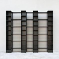 three black bookshelves sitting next to each other in front of a white wall