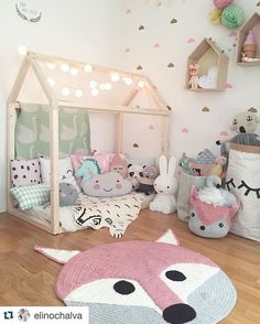 a child's room decorated in pastel colors, with stuffed animals and toys on the floor