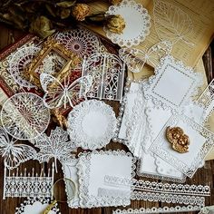 paper doily and other crafting supplies laid out on a wooden table with gold accents