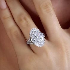 a woman's hand with a diamond ring on top of her finger and an engagement band