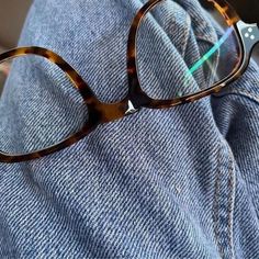 a pair of glasses sitting on top of a gray sweater