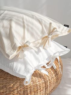 two white pillows sitting on top of a wicker basket