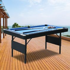 a pool table sitting on top of a wooden deck