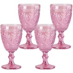 four pink glass goblets sitting next to each other