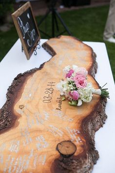 a wooden slab with flowers on it at a wedding reception