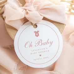 a baby shower tag with a pink bow on it