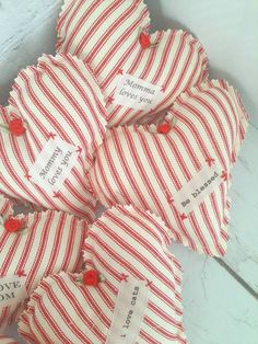 several red and white striped heart shaped candy bags with small hearts on the top one has a name tag that says mommy loves you