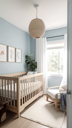 a baby's room with blue walls and white curtains