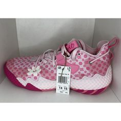 a pink and white tennis shoe with polka dots on the side, next to a price tag