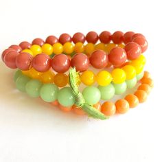 The perfect mix of citrus tones collide in this set of dark coral, light tangerine, fern green & golden yellow vintage beads. Bead sizes in this set are 10mm at the largest width. This stacking arm party set features 4 separate bracelets strung on a stretch material. One size fits most. Because the beads we use are vintage & sometimes very limited, beads may vary slightly from the design shown but the look of the overall design & color way will be the same. Leetie stack & stretch bracelets look Adjustable Orange Stackable Beaded Bracelets, Adjustable Stackable Orange Beaded Bracelets, Yellow Stackable Beaded Bracelets, Orange Stackable Beaded Bracelets For Gifts, Orange Stackable Beaded Bracelets As Gift, Orange Stackable Bracelets With Round Beads, Stackable Orange Round Beaded Bracelets, Orange Stackable Jewelry With Round Beads, Orange Stackable Round Bead Jewelry