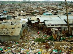 an aerial view of a slum city with lots of trash in the foreground