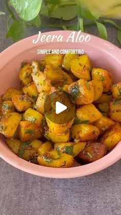 a pink bowl filled with cooked vegetables on top of a table